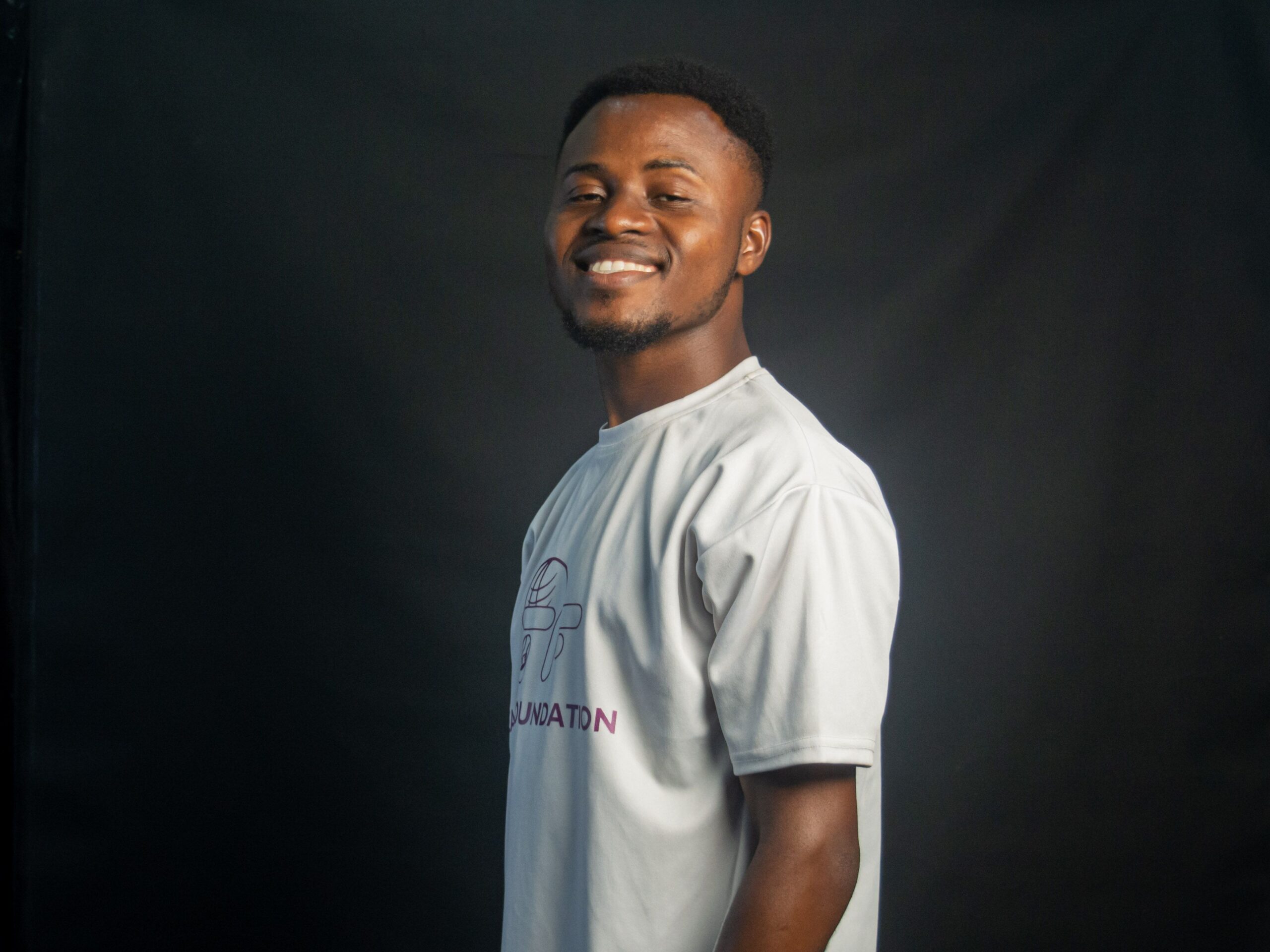 Cheerful young man posing and smiling in a studio setting.